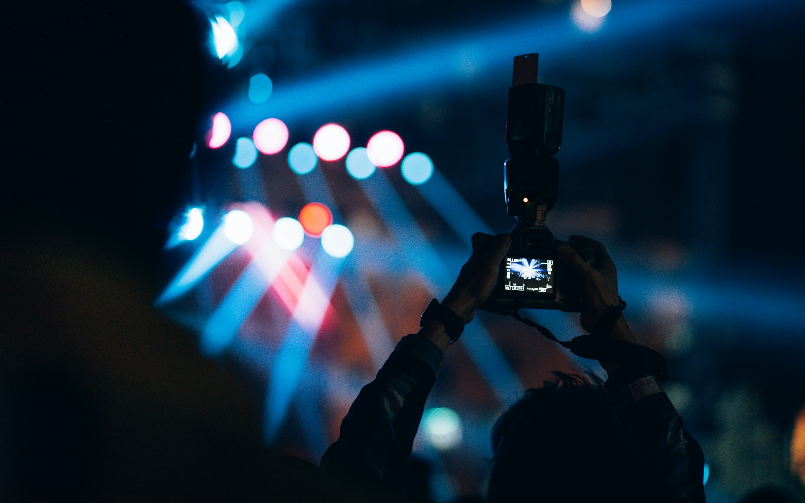 Presenter on stage with screens